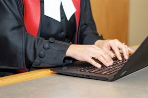 A court official works at a laptop computer.
