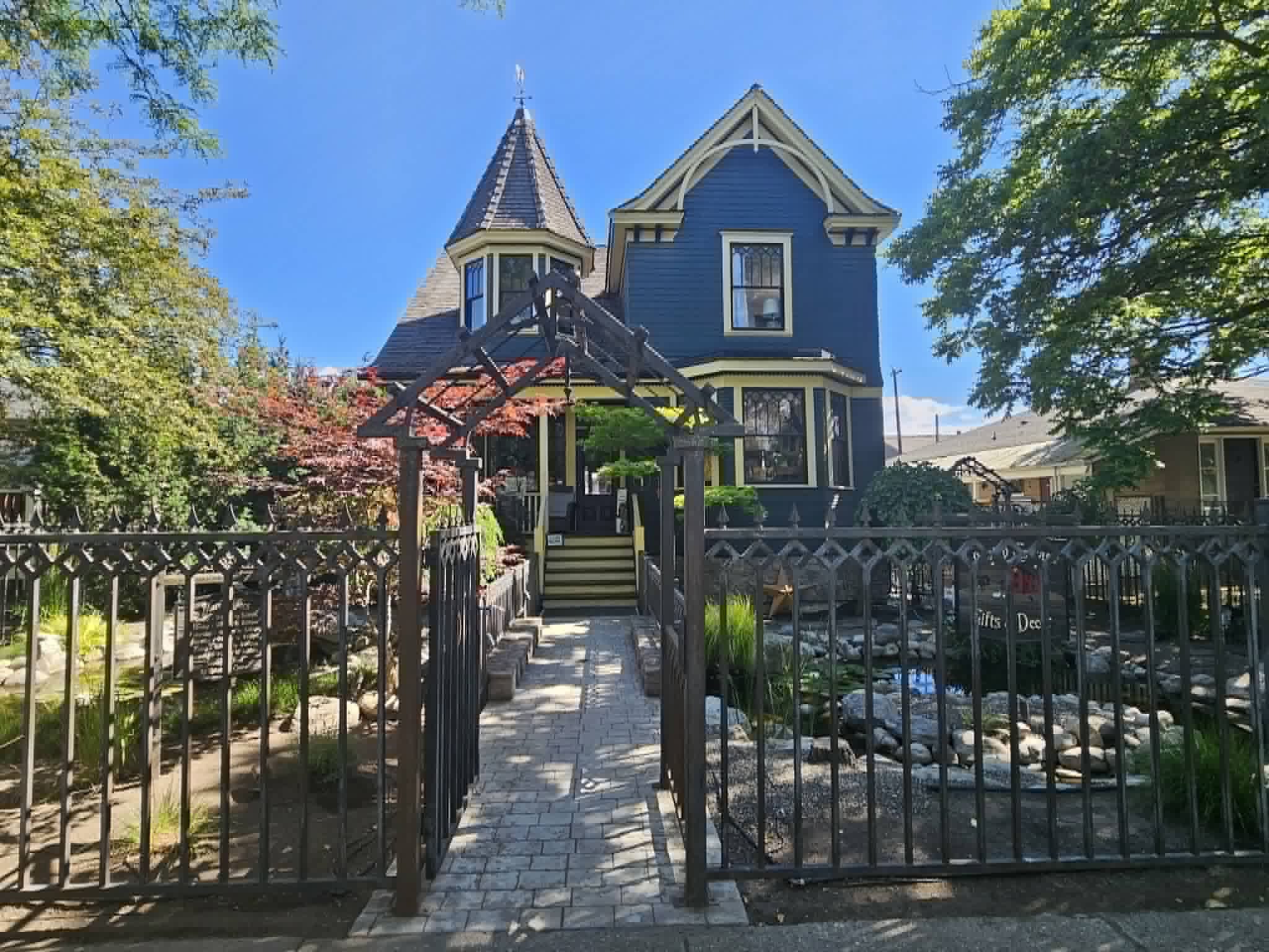 A heritage house with an iron fence is shown.