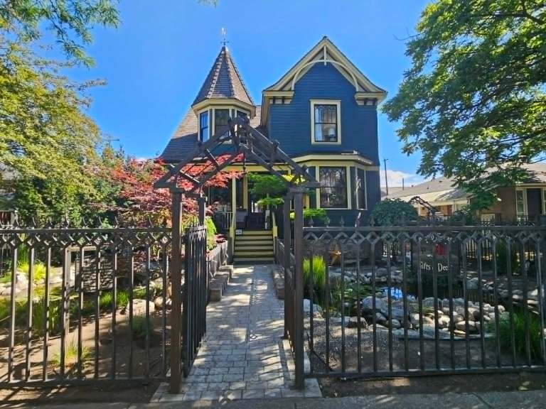 A heritage house with an iron fence is shown.