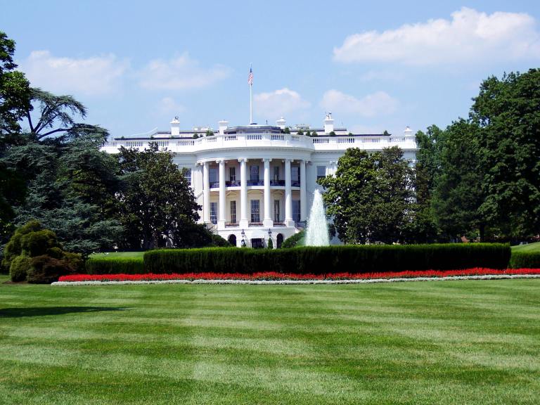 The U.S. White House is seen with a green lawn in the foreground.