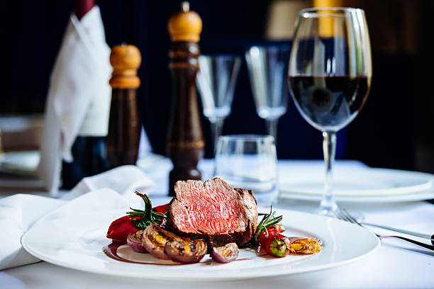 Kelowna gains international gastronomy status | iNFOnews.ca A plate of gourmet food is on a white tablecloth with a glass of red wine on the right side.