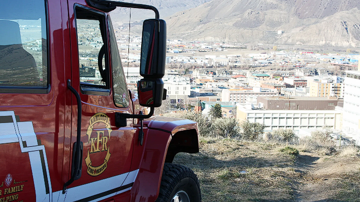 A fire truck at a lookout over a city