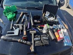 A collection of illegal weapons on the hood of a vehicle.