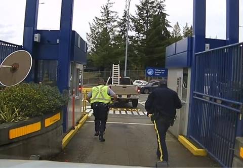 Kelowna father arrested for impaired driving at Horseshoe Bay ferry terminal | iNFOnews.ca Two police officers running up to a brown truck at a ferry terminal.