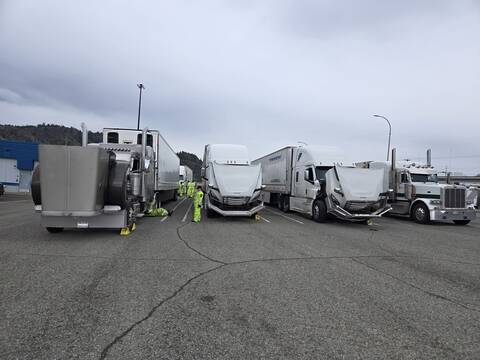 A lineup of commercial trucks with BC Highway Patrol and other examiners at a check stop near Kamloops.