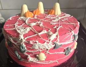 A pink cake has a Halloween theme.