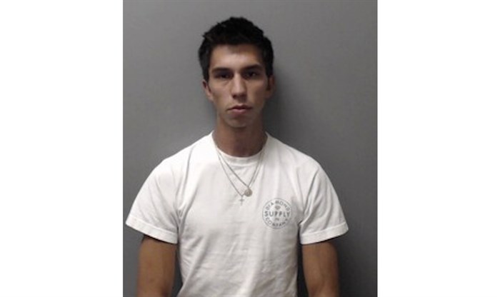 Brown haired man in a white shirt.