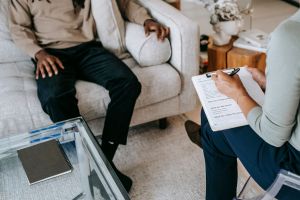 A person writes notes during a therapy session