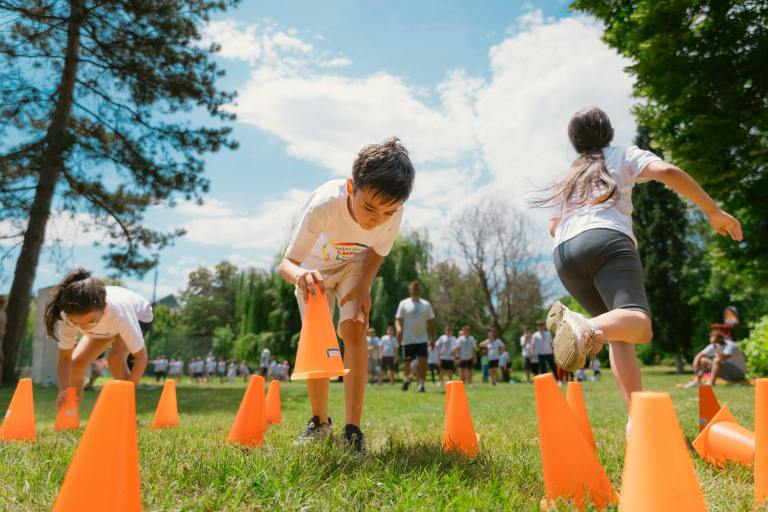 A child lifts a cone during a school race.