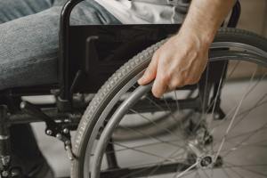 A person holding a wheelchair