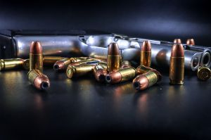 A handgun on a table with cartridges.