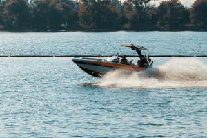 A speed boat travels along a lake.