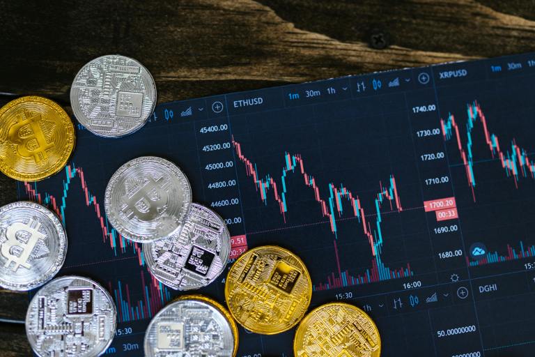 BC woman sues crypto platform after losing $670,000 in scam | iNFOnews.ca Bitcoins and a graph on a computer screen.