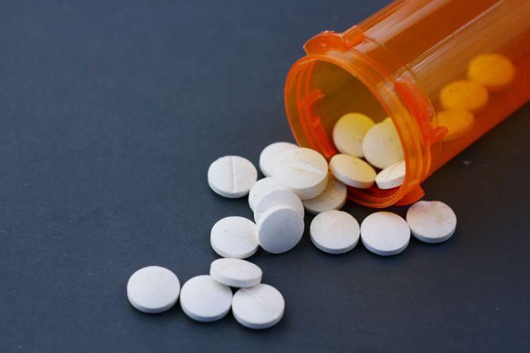 a pill bottle tipped over with spilt pills
