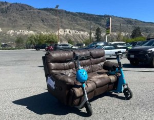 A leather sofa sits on two scooters.