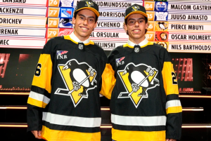 Two young men wearing NHL jerseys pose for a photo.