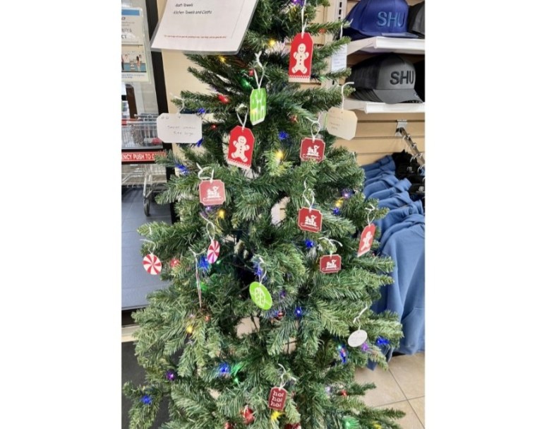 A small artificial Christmas tree is adorned with paper decorations.