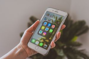 A person looking at the cell phone they are holding.