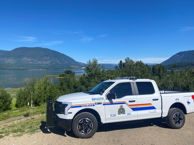 An RCMP pick-up truck in front of a lake.
