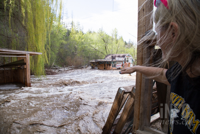 Woman looking at property damaged by flooding.