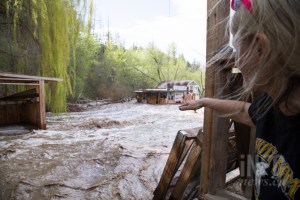 Woman looking at property damaged by flooding.